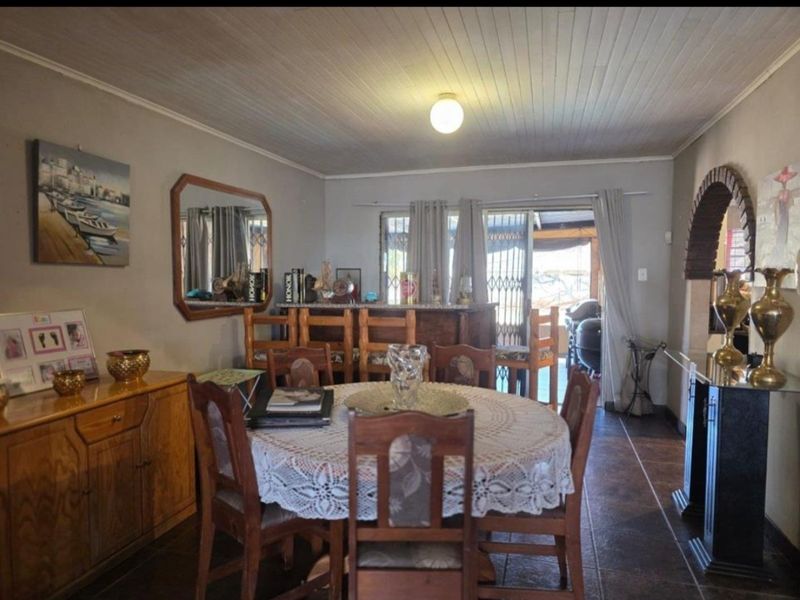 Dining room featuring tiled flooring, a timber ceiling, and a brick archway, with direct access to an outdoor patio area through sliding glass doors.