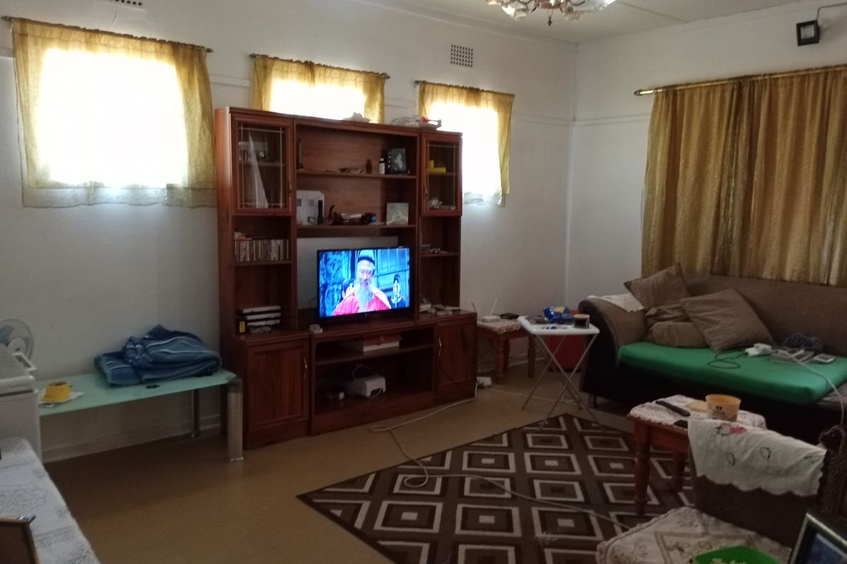 A living room featuring tiled flooring and ceiling ventilation, providing a functional space for relaxation.