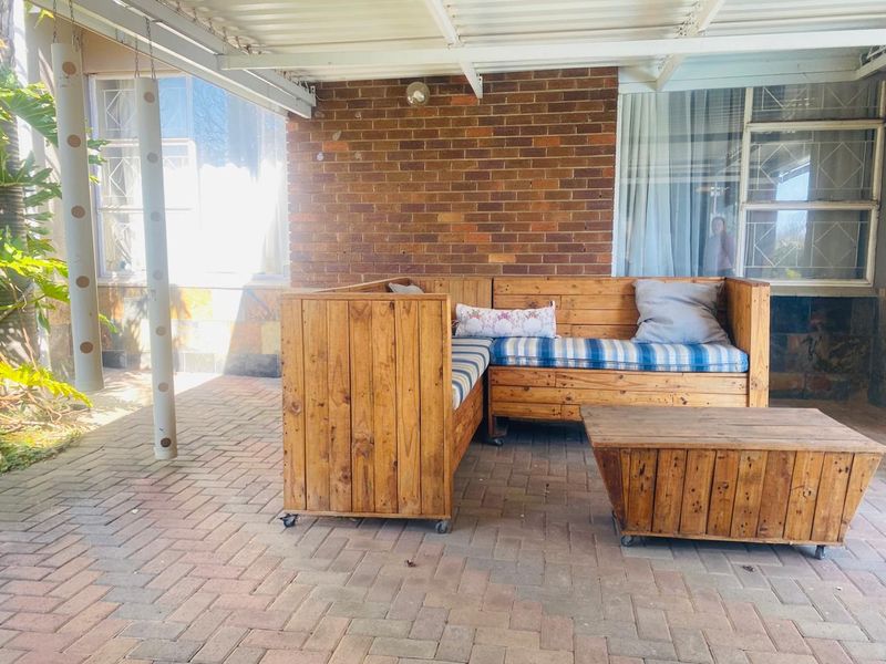 A covered outdoor patio area featuring brick paving and an exposed brick wall, providing a functional space for outdoor relaxation.