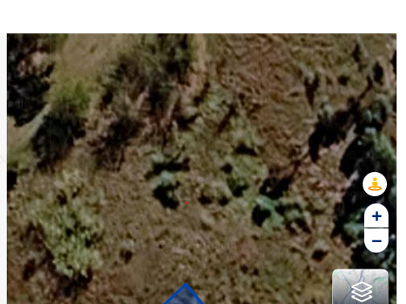 An aerial satellite view of the vacant residential land plot showing natural terrain and vegetation.