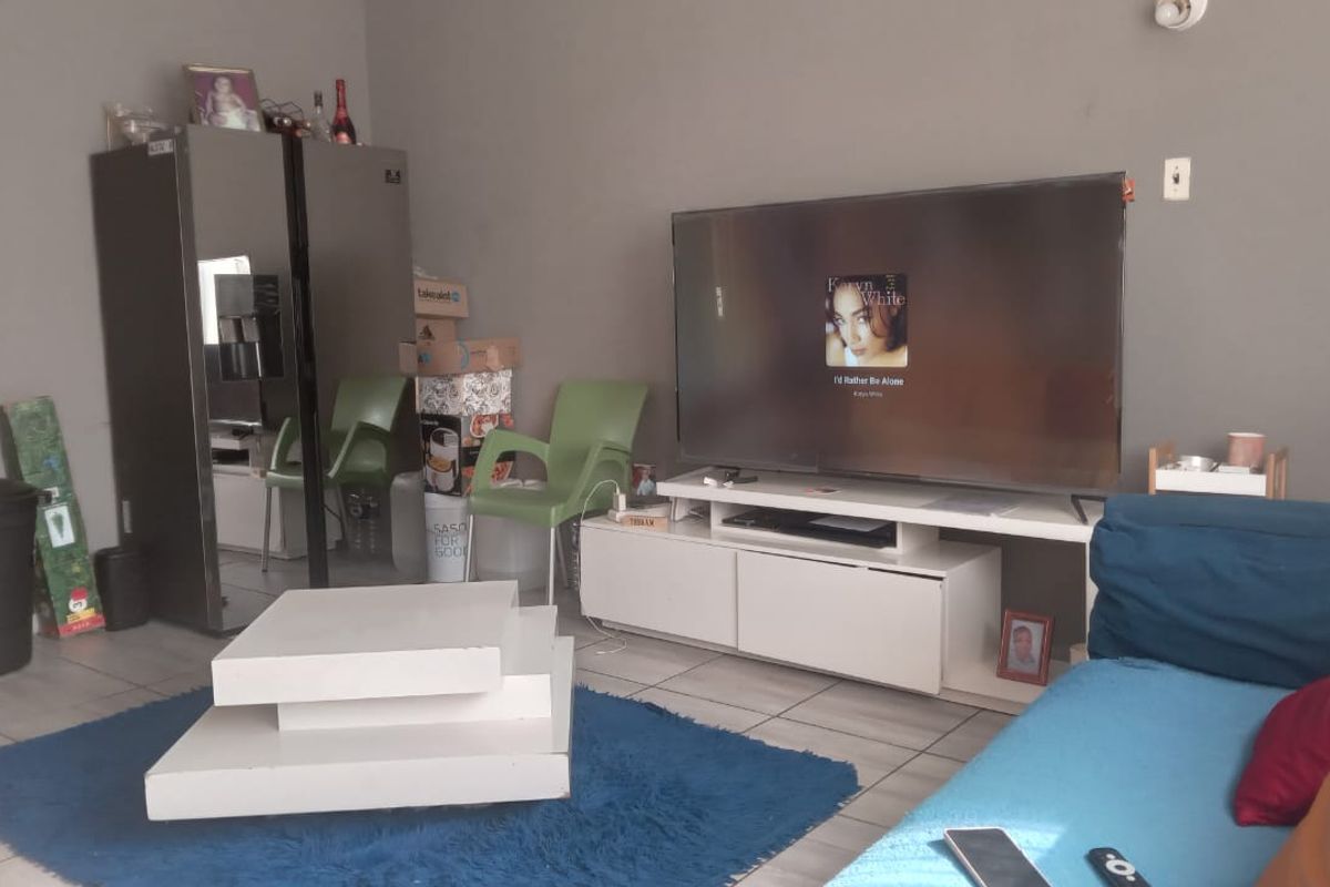 A living room area featuring tiled flooring and neutral wall finishes, providing a functional space for relaxation.