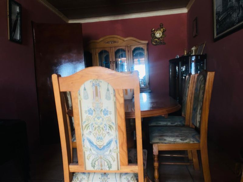 A dining room featuring dark wall finishes and crown molding, providing a traditional space for formal meals.