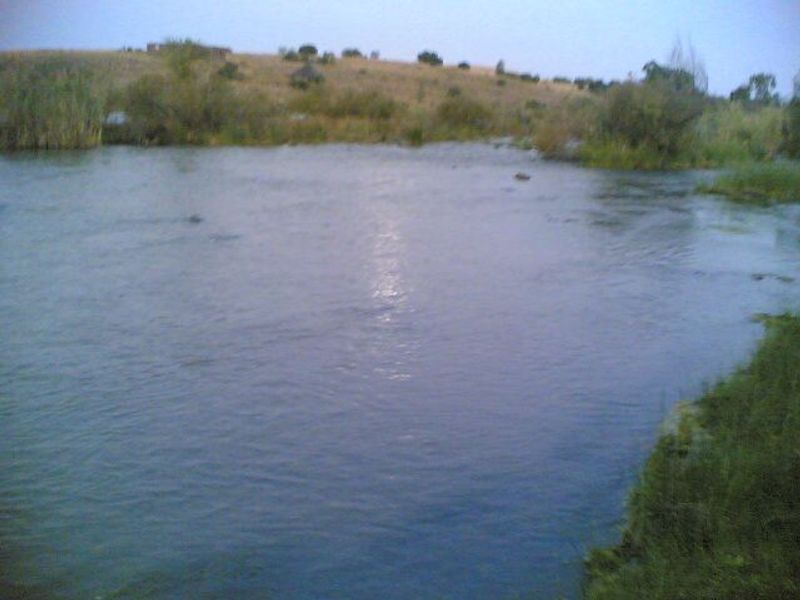 A scenic view of a natural river flowing through the small holding property landscape.