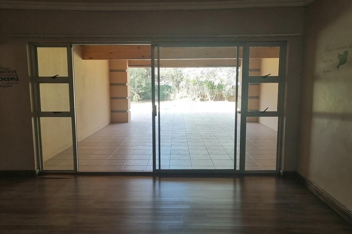 Interior view looking through large sliding glass doors onto a covered patio area with tiled flooring.