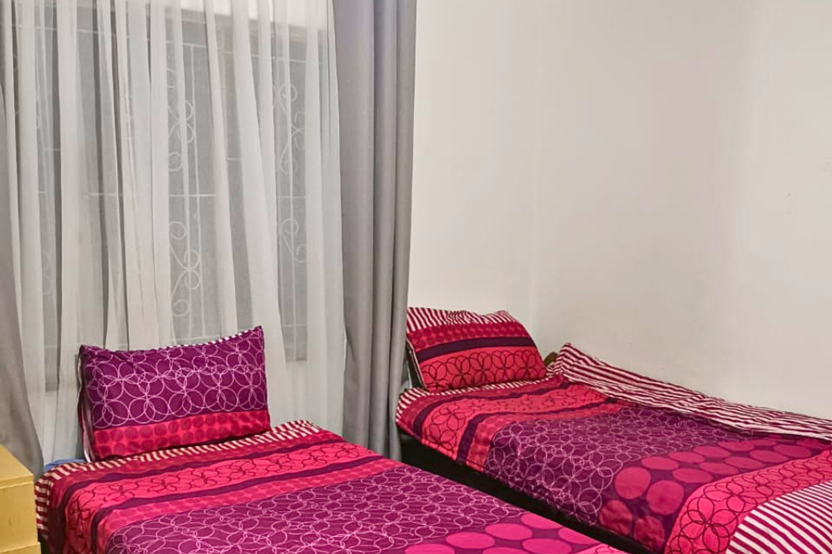 A functional bedroom featuring a window with security bars and neutral wall finishes.