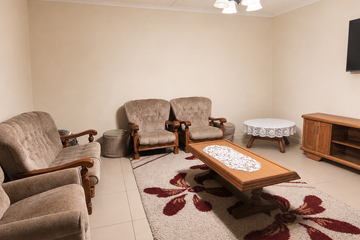A spacious living room featuring neutral tiled flooring and a central ceiling light fixture, providing a functional and comfortable area for relaxation.
