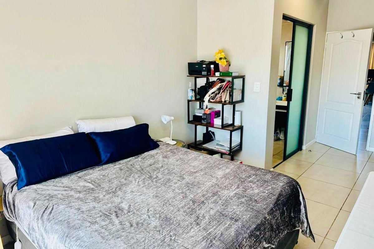 A bedroom featuring tiled flooring, a frosted glass door leading to an en-suite, and a standard panel door.