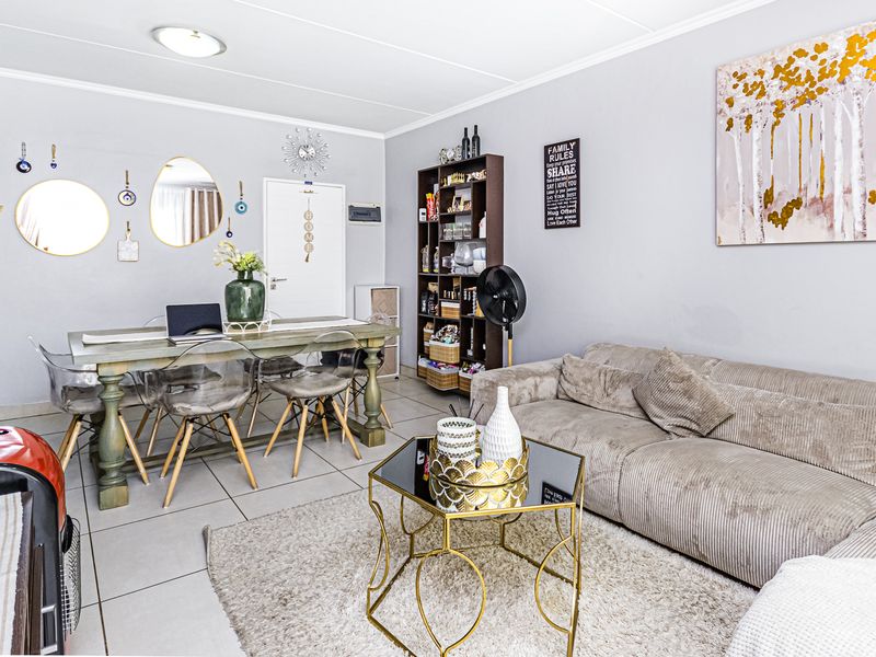 An open-plan living and dining area featuring neutral tiled flooring and a bright, functional layout suitable for comfortable daily living.