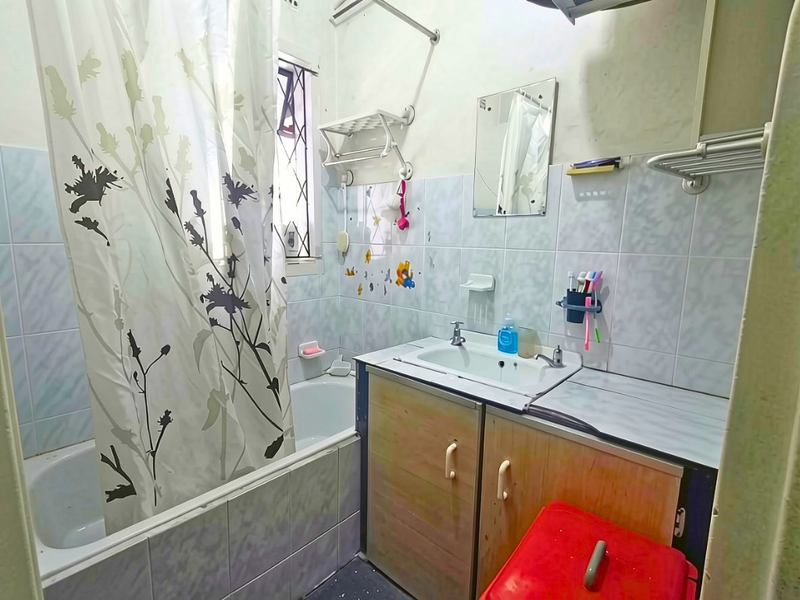 A compact bathroom featuring a bathtub with shower curtain, a vanity cabinet with integrated basin, and tiled wall finishes.