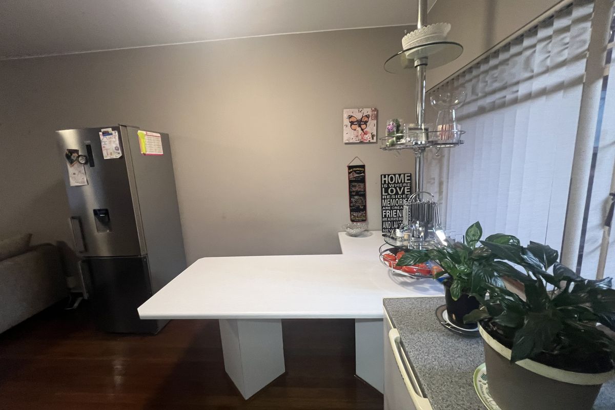 A kitchen area featuring a built-in breakfast bar, laminate countertops, and hardwood flooring.