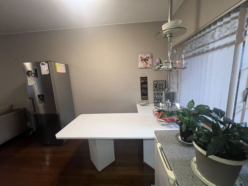 A kitchen area featuring a built-in breakfast bar, laminate countertops, and hardwood flooring.