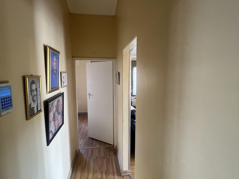 A functional hallway featuring laminate wood flooring and access to adjacent rooms.
