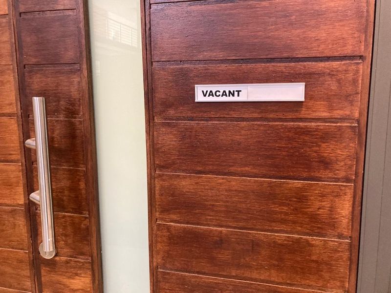 A close-up view of a modern timber entrance door featuring a frosted glass panel and a stainless steel pull handle.