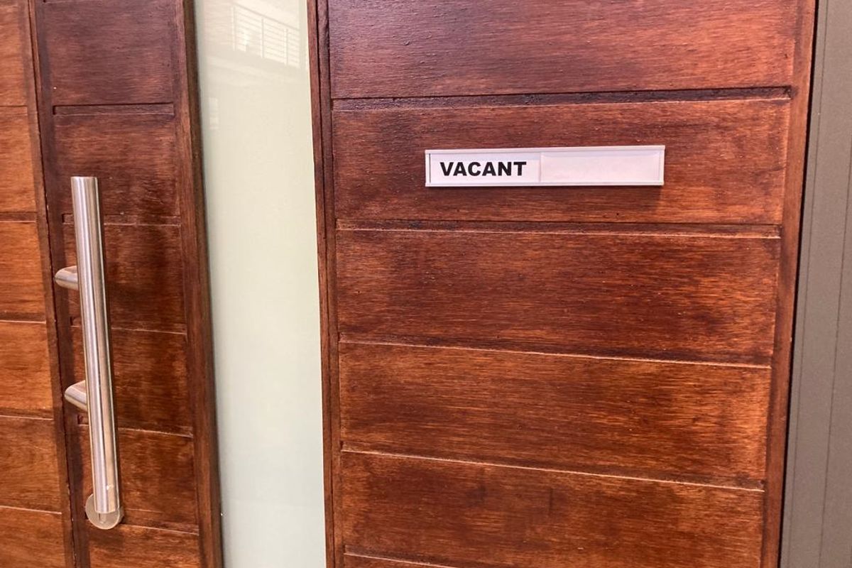 A close-up view of a modern timber entrance door featuring a frosted glass panel and a stainless steel pull handle.