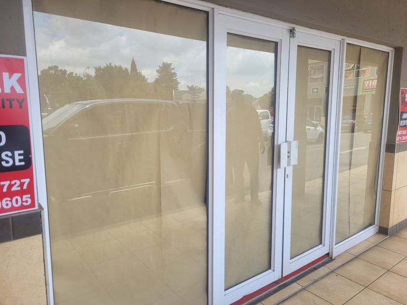 Front entrance of a retail property featuring aluminium framed glass doors and tiled flooring, suitable for a shopfront or office space.