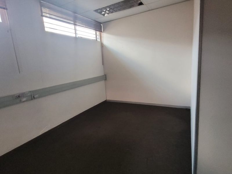 A vacant office space featuring carpet flooring, surface-mounted electrical trunking, and recessed ceiling lighting.