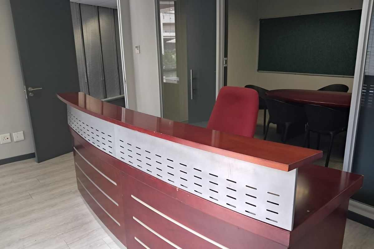 Professional office space featuring a reception desk, glass partitions, and a dedicated meeting area with a built-in chalkboard.