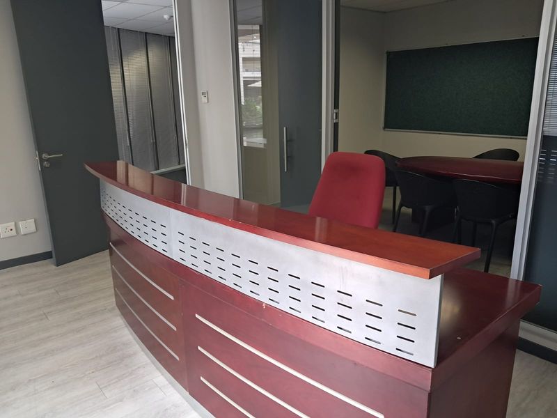Professional office space featuring a reception desk, glass partitions, and a dedicated meeting area with a built-in chalkboard.