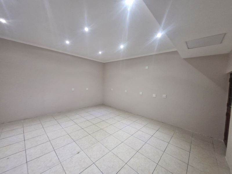 A clean, empty office space featuring neutral wall finishes, tiled flooring, and recessed ceiling lighting, ready for professional fit-out.