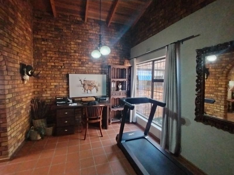 A multi-purpose office space featuring exposed brick walls, timber beam ceilings, and terracotta floor tiles, offering a rustic aesthetic.