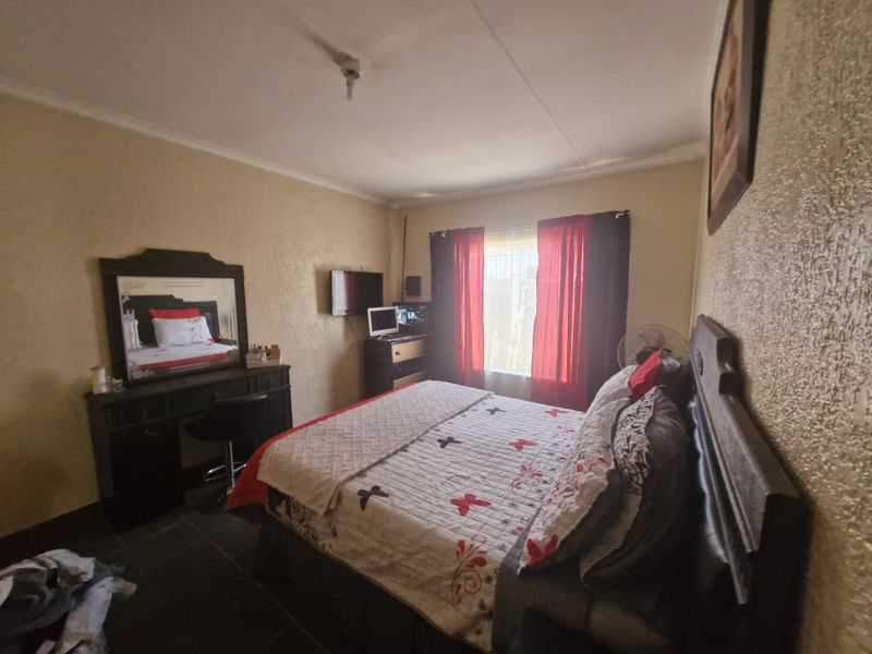 A standard bedroom featuring tiled flooring and textured wall finishes, providing a functional living space.