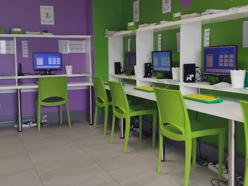 A functional office space featuring multiple built-in desk workstations, tiled flooring, and recessed ceiling lighting, suitable for a collaborative work environment.