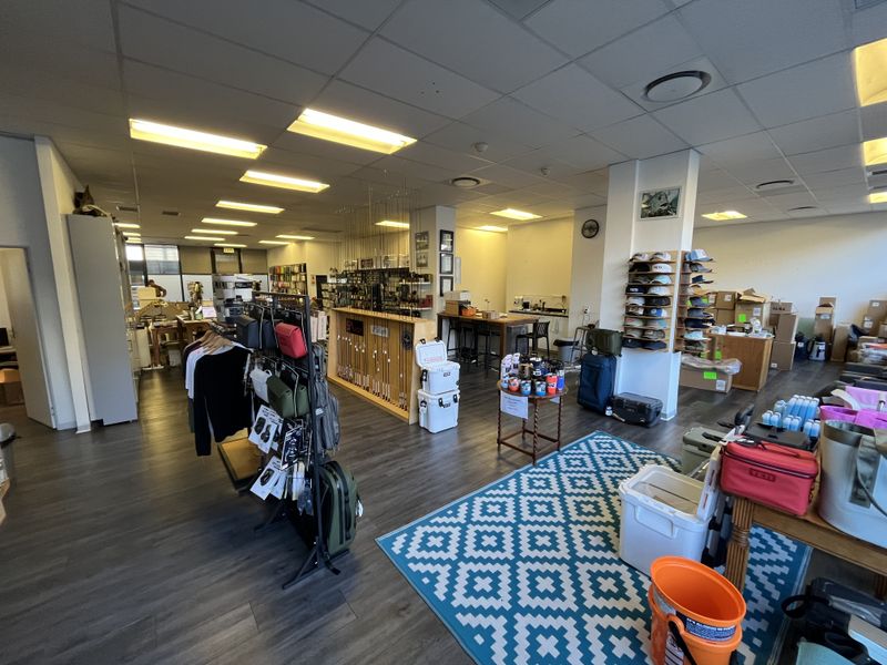 Open-plan office space featuring suspended ceilings, recessed lighting, and durable laminate flooring, currently utilized as a retail showroom.