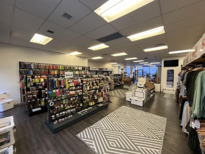 A well-lit commercial office or retail space featuring a suspended ceiling, recessed lighting, and durable laminate flooring throughout the open floor plan.