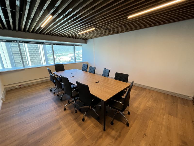 Modern office boardroom featuring a slatted timber ceiling, linear lighting, and large windows with city views, finished with high-quality laminate wood flooring.