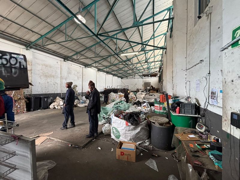 Large industrial utility space featuring high ceilings with exposed steel roof trusses and concrete flooring, suitable for storage or light manufacturing operations.