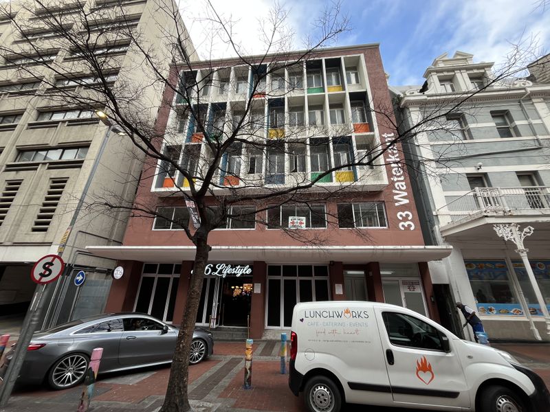 Front elevation of a multi-story commercial office building featuring a distinctive grid-pattern facade and ground-level retail or office entrance.