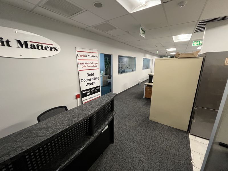 Professional office space featuring a reception area, carpeted flooring, suspended ceilings with recessed lighting, and internal glass partitions for a bright, functional workspace.