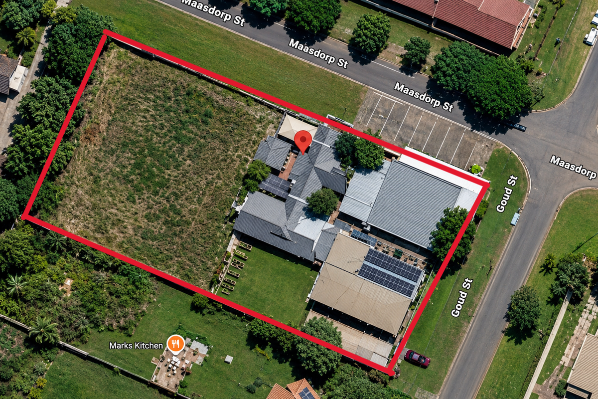 Aerial view of the restaurant property featuring a large plot, paved parking, solar panel installation, and established garden areas.