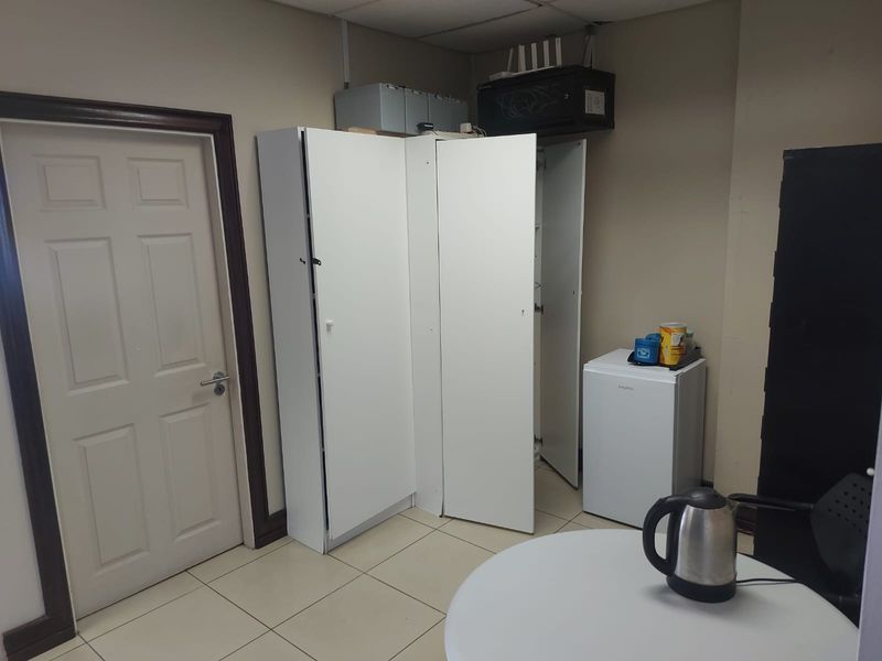 A functional utility or storage area featuring tiled flooring and built-in cabinetry, suitable for office supplies or breakroom storage.