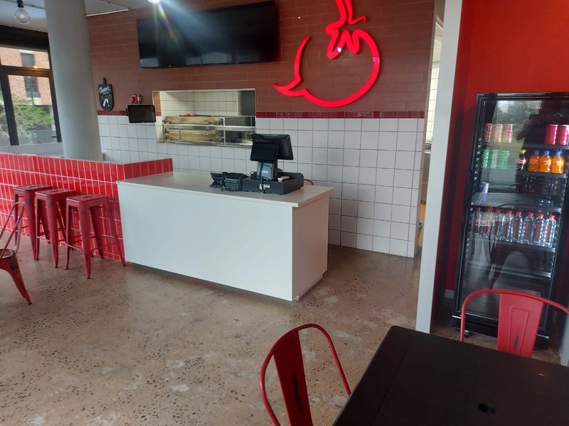 A modern retail service area featuring a service counter, polished concrete flooring, and a combination of brick and tiled wall finishes.