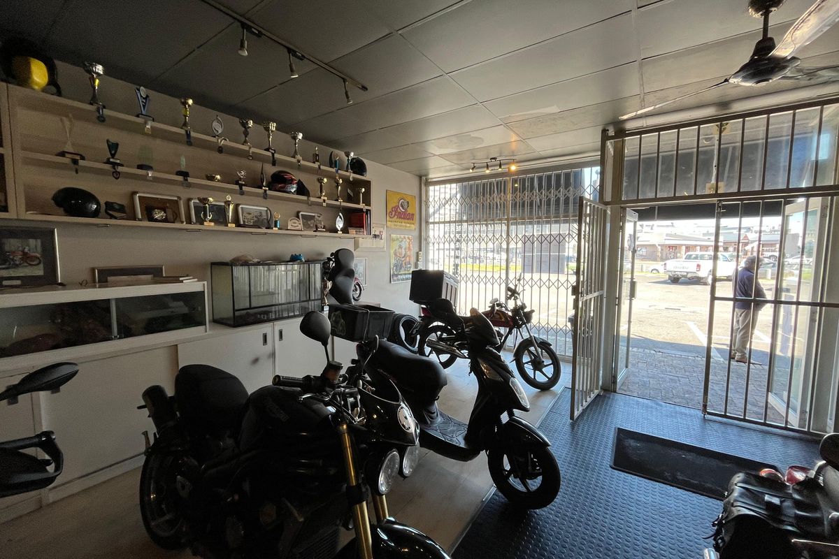 A functional garage space featuring built-in shelving, durable rubber flooring, and secure metal gate access, suitable for vehicle storage or workshop use.