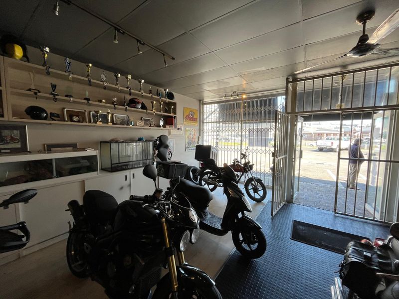 A functional garage space featuring built-in shelving, durable rubber flooring, and secure metal gate access, suitable for vehicle storage or workshop use.