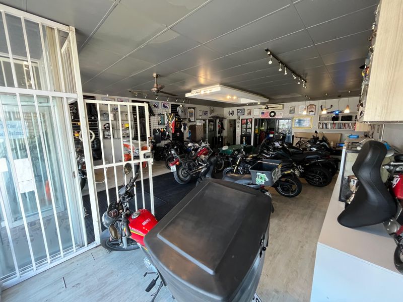 Spacious garage area currently utilized for motorcycle storage, featuring track lighting, ceiling fan, and integrated shelving units.