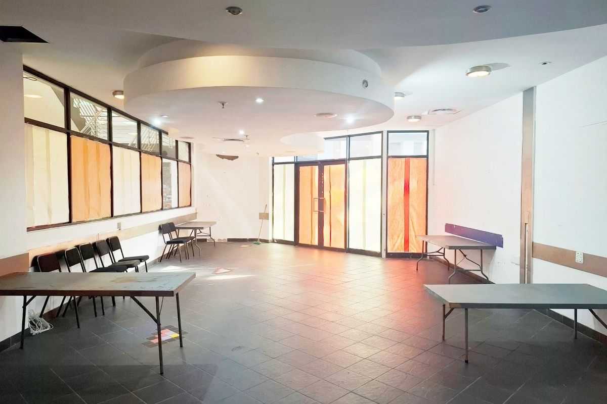 Open-plan retail space featuring tiled flooring, recessed ceiling lighting, and a large glass storefront entrance, suitable for various commercial business applications.