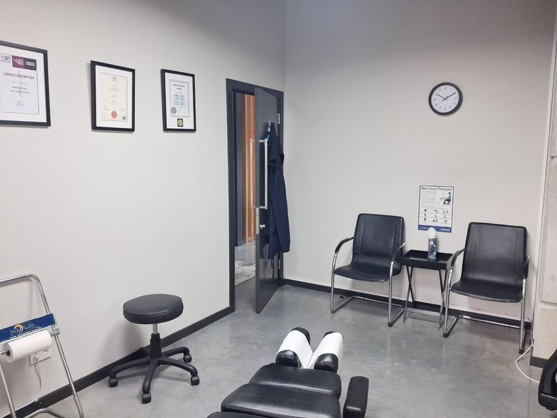 A functional commercial office or treatment room featuring polished concrete floors and a clean, professional layout suitable for clinical or administrative use.