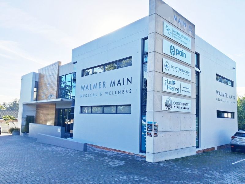 Modern commercial medical and wellness building featuring prominent signage, paved driveway, and contemporary architectural finishes.