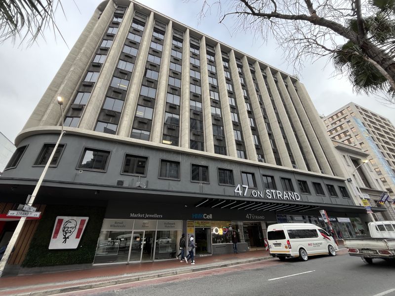 A multi-story commercial office building located at 47 on Strand, featuring ground-floor retail storefronts and a prominent street-facing facade.