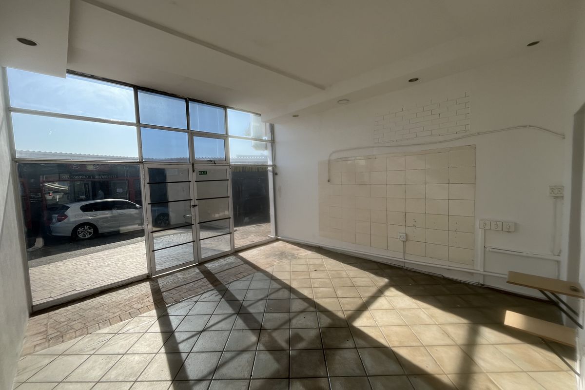 Empty commercial storefront space featuring large glass windows, tiled flooring, and recessed lighting, suitable for a retail or office setup.