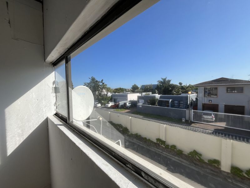 A view from an interior window looking out over a residential street and neighbouring properties.