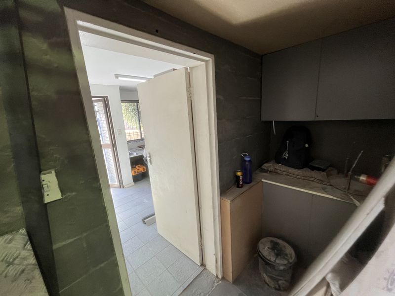A functional scullery or utility area featuring built-in cabinetry and counter space, providing additional storage and prep utility for the industrial property.