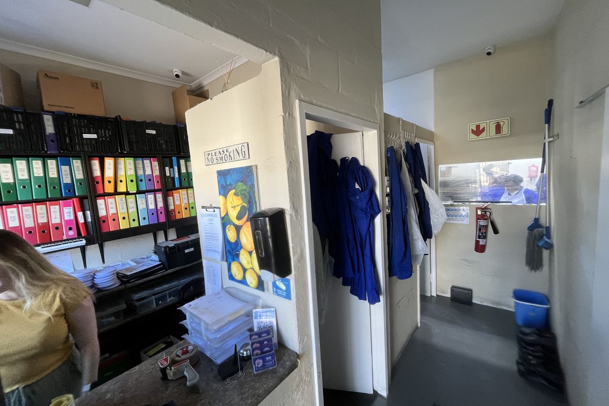 A functional utility and storage area featuring built-in shelving, a service counter, and essential safety equipment including a fire extinguisher.