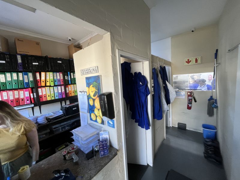 A functional utility and storage area featuring built-in shelving, a service counter, and essential safety equipment including a fire extinguisher.