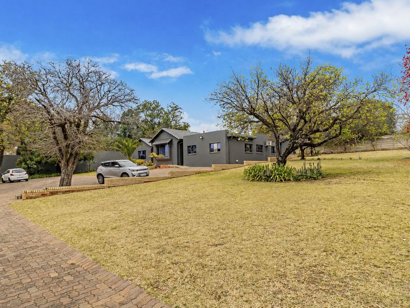 Front view of the office property featuring a paved driveway, landscaped garden, and a well-maintained building exterior with a tiled roof.