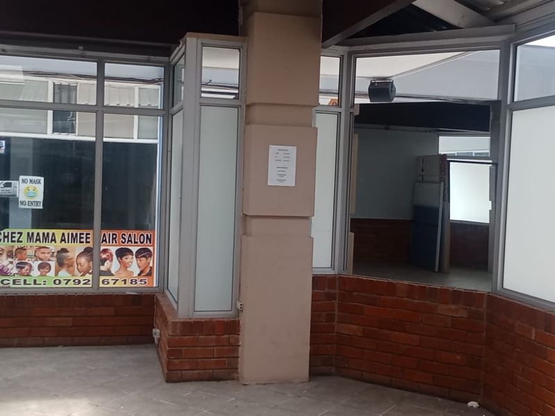 Front exterior view of a retail storefront featuring brick base walls, aluminium framed glass windows, and existing business signage.
