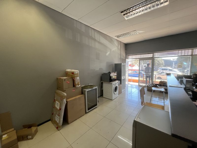 Commercial office space featuring tiled flooring, recessed lighting, and a glass storefront entrance with an integrated reception counter.